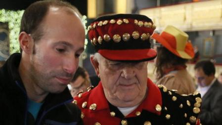 Dos personas de los que han acudido al Teatro Real de Madrid para asistir en directo al sorteo extraordinario de Navidad, el más esperado del año, que distribuye hoy 2.240 millones de euros en más de 24 millones de premios. EFE/Fernando Alvarado