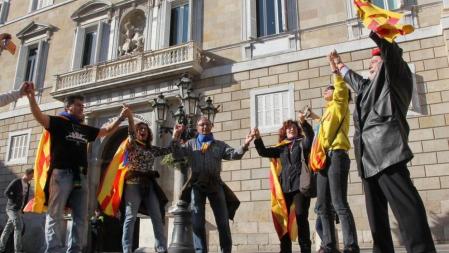 Un grupo de personas con banderas independentistas ante el Palau de la Generalitat donde crece la expectación a la espera de que el presidente Mas mantenga los últimos contactos con ERC y las entidades soberanistas