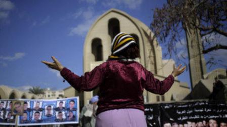 Una mujer reza por la liberación de los 21 comptos que finalmente han sido ejecutados por el Estado Islámico