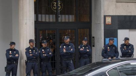 La policía custodia la puerta del edificio en el que se encuentra la casa del exministro Rodrigo Rato, en el que ha tenido lugar un registro