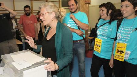 La candidata a la alcaldia de Barcelona por la CUP, María Jose Lecha, acompañada por el diputado David Fernández y miembros de la CUP, vota en la Escola Mirella de Barelona.