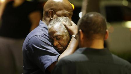 Dos hombres lloran tras el tiroteo en un templo metodista en Carolina del Sur