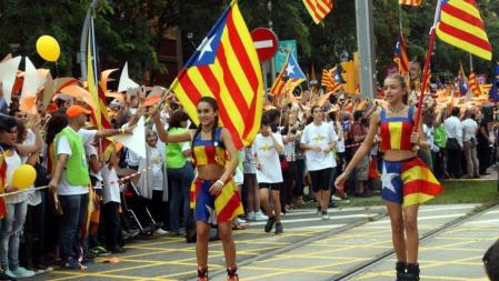 Dos chicas con patines y senyeres anuncian la llegada del gigante puntero amarillo