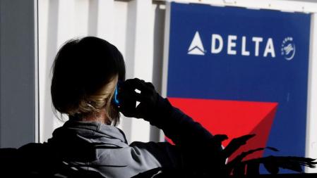 Una pasajera habla por teléfono en una puerta de embarque de Delta Airlines <br>