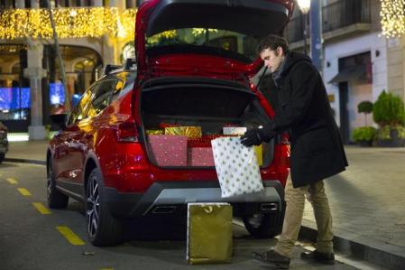 Un hombre carga el maletero de su coche con regalos navideños&nbsp;