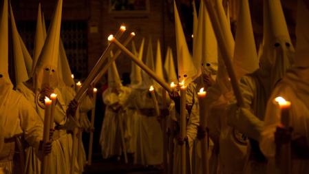 Nazarenos en una procesión nocturna de la Semana Santa sevillana