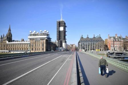 Las grandes ciudades europeas como Londres han experimentado un notable descenso en cuanto a las emisiones de dióxido de carbono debido a la ausencia casi absoluta del tráfico. En la imagen, un hombre cargado con bolsas camina por el puente de Westminster, una de las zonas más turísticas de la capital inglesa