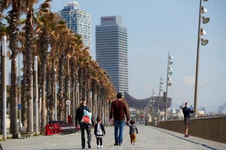 Una familia disfruta del día soleado en el paseo marítimo de Barcelona