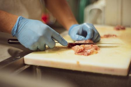Persona con guantes manipulando carne