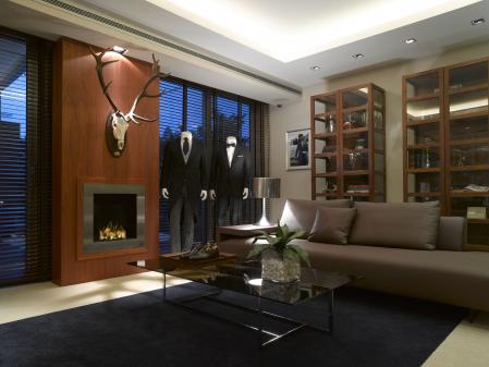 Los clientes son recibidos con una copa de champán francés y pueden relajarse en este espacio con chimenea, mientras los dependientes, que conocen sus gustos, les buscan la prendas