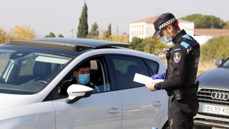 Un agente de la Guardia Urbana mirando el papel justificante de movilidad en un control en la N-230 dirección Lleida