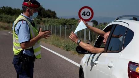 GRAF2444. EL SEGRIÀ, 04/07/2020.- Un Mosso d'Esquadra realiza un control de carreteras en la comarca del Segrià, este sábado. El alcalde de Lleida, Miquel Pueyo, ha asegurado que ante el confinamiento de la comarca del Segrià a causa de los brotes por coronavirus, 