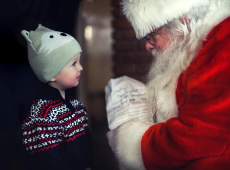 Un niño entregando la carta a Papa Noel.