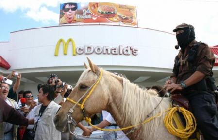 Marcos pasa a caballo ante un McDonald's de Cancún en el 2006