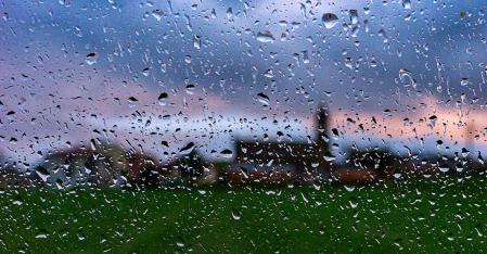 Amanece en Sentfores con el cielo ligeramente rojizo entre la lluvia.