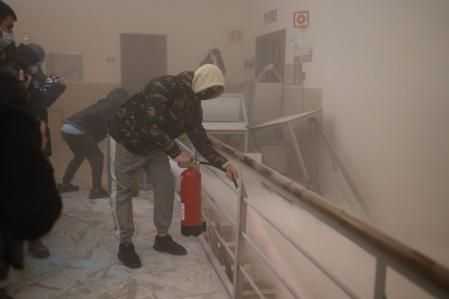 Una de las personas que trata de impedir el paso de los Mossos emplea un extintor contra los agentes