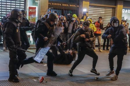 Agentes de policía (CNP) dispersan a manifestantes durante una protesta que condenaba el arresto del cantante de rap Pablo Hasél, en la madrilena y centrica Plaza del Sol
