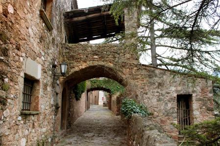Esta calle de Mura está decorada con un arco que sirve como terraza de una vivienda.