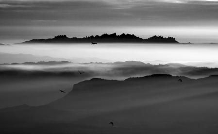 Montserrat vista desde el Santuario de Bellmunt, en Osona, con buitres volando.