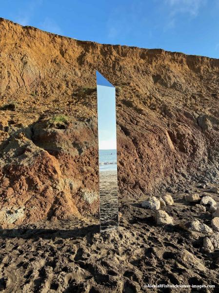 ha aparecido un monolito en la Isla de Wight, según imágenes tomadas el domingo (6 de diciembre). ..Alexia R Fishwick capturó la escena en una playa en la isla frente a la costa sur de Gran Bretaña. La estructura reflejada sigue a estructuras monolíticas similares que se han descubierto en todo el mundo, con una encontrada en Utah el mes pasado y otras en Rumania y California. ..Alexia explica: “Solo fui a caminar. Allí estaba. Mucha gente pasó junto a él y lo ignoró. Me quedé estupefacto. Sabía de los otros monolitos. Increíblemente elegante… Alexia describió además el monolito como “altura 7.5 pies, ancho 2 pies, sección triangular, ubicado sobre la línea de la marea