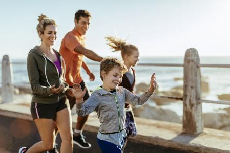 Close up of a family running alongside the sea