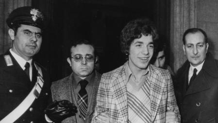 Giuseppe Pelosi (segundo por la derecha, con chaleco y chaqueta a cuadros) es escoltado por la policía a su llegada al juzgado de menores, acusado del asesinato de Pier Paolo Pasolini