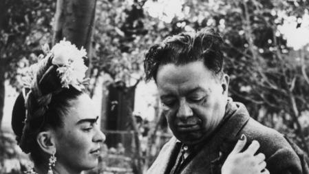 1945: Artista mexicano Frida Kahlo (1907 - 1954) acaricia a su mascota un mono, posiblemente Fulang-Chang, subido a la chaqueta de su marido, artista mexicano Diego Rivera (1886 - 1957)