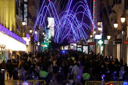 MADRID, 08/12/2020.- Personas se congregan para disfrutar de las luces navideñas en la calle de Preciados, este martes en Madrid. España encara el final del puente festivo de la Constitución sin 