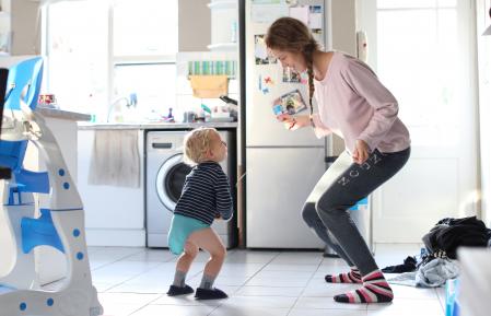 Mom and toddler dancing in the kitchen at home in their pj's