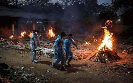People carry a body of a man, who died from the coronavirus disease (COVID-19), during his cremation at a crematorium in New Delhi, India May 3, 2021. REUTERS/Adnan Abidi