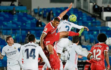 Sevilla's Brazilian defender Diego Carlos (L) vies with Real Madrid's Brazilian defender Eder Militao during the Spanish League football match between Real Madrid CF and Sevilla FC at the Alfredo di Stefano stadium in Valdebebas, on the outskirts of Madrid on May 9, 2021. (Photo by PIERRE-PHILIPPE MARCOU / AFP)
