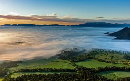 La Plana de Vic cubierta en parte por la niebla y al fondo el monte Montseny.