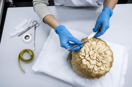 Con cuidado  
La restauradora Beatriz Urbano analiza el estado de un sombrero de paja de Balenciaga pocos días antes de la exposición