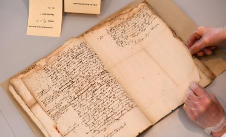 18 March 2019, Lower Saxony, Buxtehude: Gudrun Kühl, restorer, takes a look at original files from the city archives on the witch trials in Buxtehude between 1540 and 1644, which she is to restore. Photo: Carmen Jaspersen/dpa (Photo by Carmen Jaspersen/picture alliance via Getty Images)