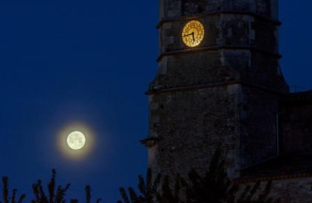 Superluna de las flores con el reloj del campanario de la iglesia de Sant Bartomeu del Grau.