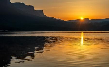 El pantano de Sau con el sol al fondo.