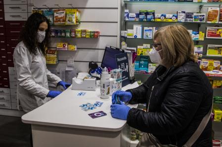 20 - 04 - 2020  / Barcelona / Farmacia Llibertat / Reparto de mascaras a cargo de la tarjeta sanitaria / En la farmacia no habian recibido sobres para entregar la máscara y los ponia la farmaceutica. Algún cliente pidio la máscara sin sobre / Foto: Llibert Teixido