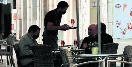 GRAFCVA5539. VALENCIA, 02/06/2021. Un camarero atiende una mesa en una terraza del centro de Valencia, cuando el paro registrado en la Comunitat Valenciana bajó en mayo un 2,77 % respecto a abril (-3,31 en toda España) y un 1,19 en el último año (-1,98 en toda España), con lo que la cifra total de desempleados en la Comunitat se sitúa en 435.265 personas. EFE/Ana Escobar