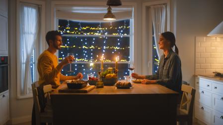Happy Young Couple in Love Have Romantic Dinner, Eating Tasty Meal in the Kitchen, Celebrating, Talking. Beautiful Lovely Husband and Wife Have Romantic Time