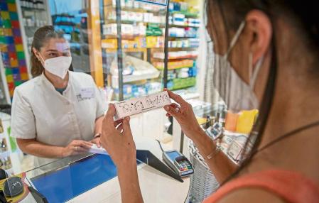 VENTA DE TEST AUTODIAGNOSTICO DE COVID EN LAS FARMACIAS. UNA CLIENTA OBSERVA LAS INSTRUCCIONES DE USO