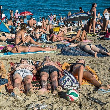 Imagen reportaje ' 24 horas en la playa ' con vida cotidiana de un dia de verano cualquiera en la playa de la Barceloneta de Barcelona. En la imagen, un grupo de jovenes turistas duerme en la playa de la Barceloneta. Playa , verano , sol , agua , vacaciones , malabar , diversion , joven , jovenes , turismo. Foto: Luis Tato