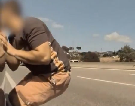 El ladrón se dispone a abrir la puerta del coche de la víctima mientras esta está siendo distraída por el cómplice del delincuente