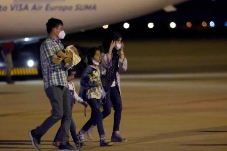 Una familia afgana atraviesa camina por las pistas de la base aérea de Torrejón de Ardoz