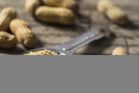 Una cucharada de polvo de arachis hypogaea deshidratado sobre una mesa de madera rústica