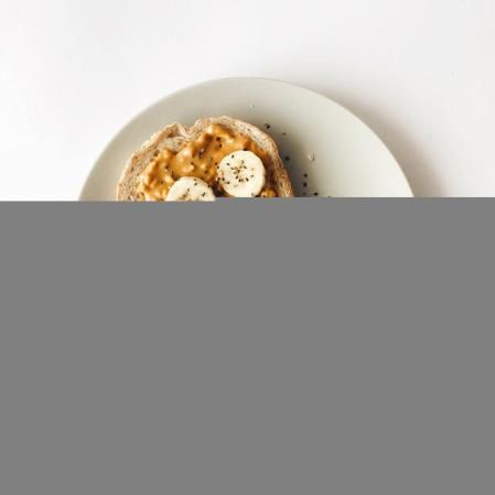 Tostada untada de mantequilla de cacahuete con plátano por encima, un saludable desayuno