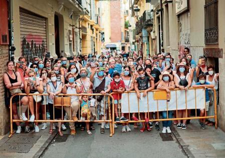 GRAFCVA8280. VALENCIA, 04/09/2021.- Un grupo de personas asiste desde un callejón a la Ofrenda a la Virgen en estas atípicas y reducidas Fallas de septiembre que han gozado de una gran respuesta popular gracias al clima aún veraniego y la sensación de cierta vuelta a la normalidad. EFE/Biel Aliño