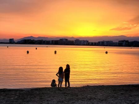 Tres niños jugando a la orilla del mar.