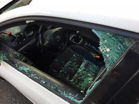 Coche destrozado tras los altercados en el macrobotellón de anoche en plaza España