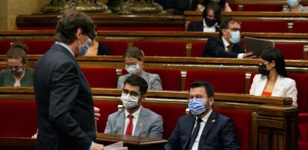 El líder del PSC, Salvador Illa (i), pasa ante el presidente de la Generalitat, Pere Aragonès (d), y su vicepresidente, Jordi Puigneró (i), durante la segunda jornada del debate de política general, un día después de la intervención inicial del presidente Aragonès ante el pleno del Parlament.
