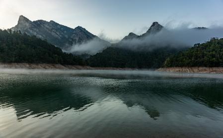 La Serra de Picancel reflejada en el agua entre brumas y niebla.